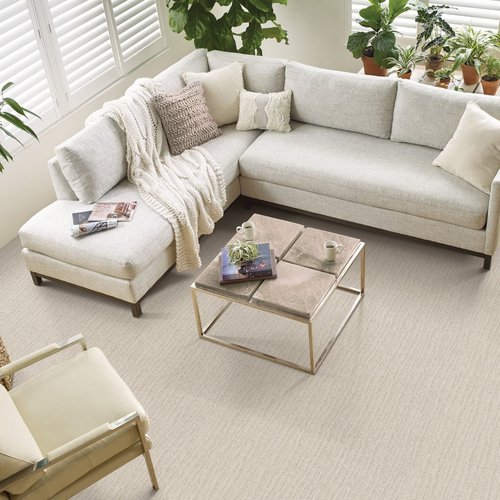 Photo of a living room taken from above with an L shaped couch, coffee table and beige carpet from Floors Of Wilmington in the Wilmington, NC area